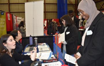 Students meeting staff at a career fair booth